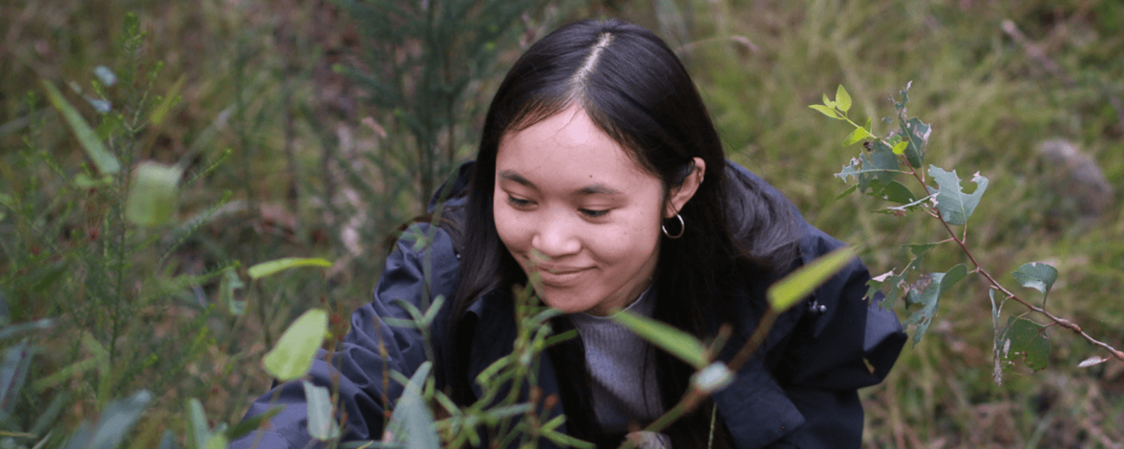 A woman looking at a plant
