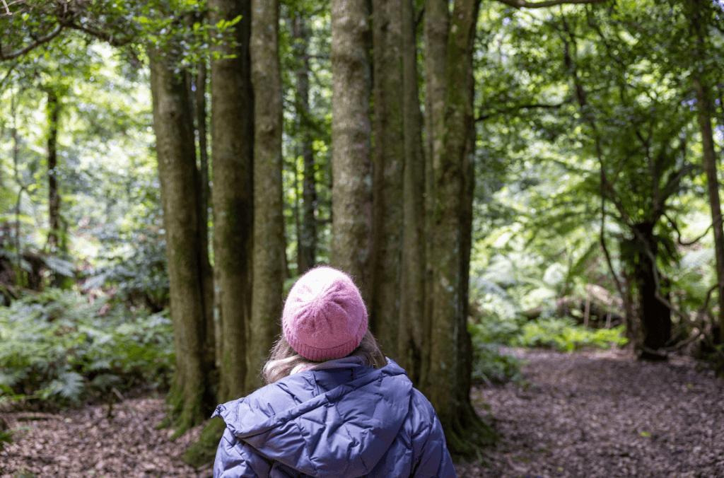 Long hair and beanie walking away in jungle walk