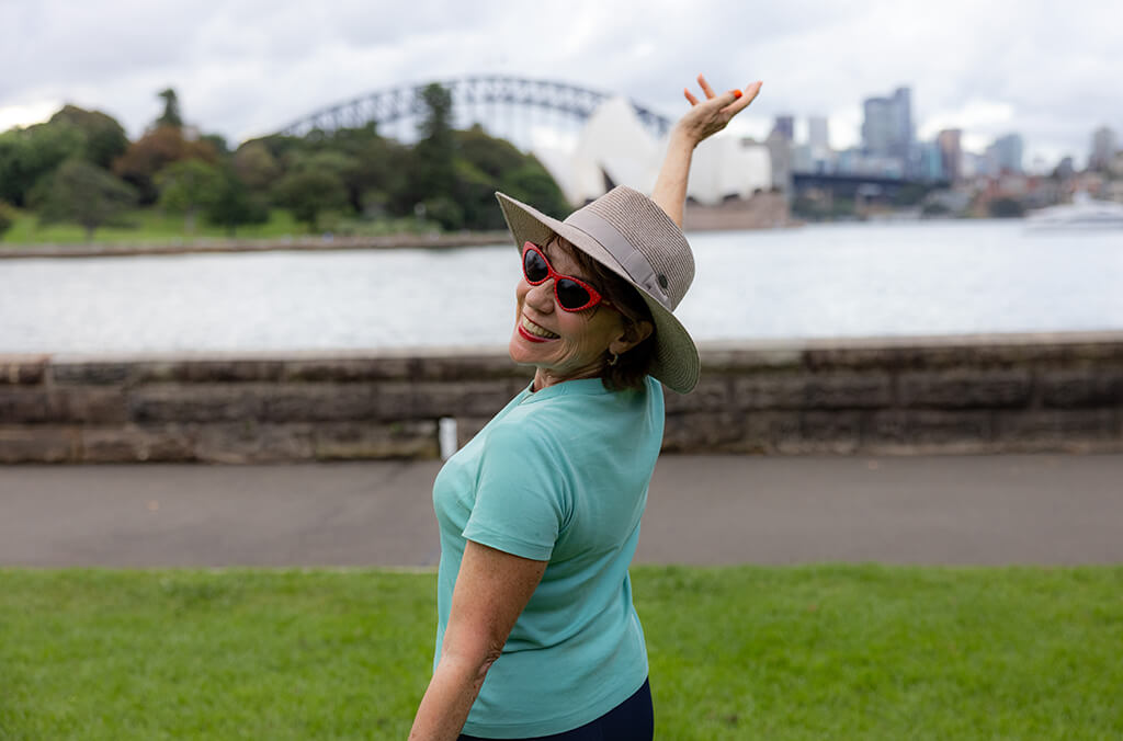Kathy Lette in front of the Sydney Harbour Bridge and Sydney Opera House