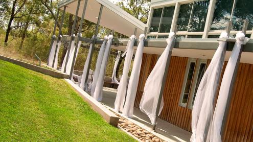 Lawn and verandah of The Bowden Centre with white cloth hanging in verandah.