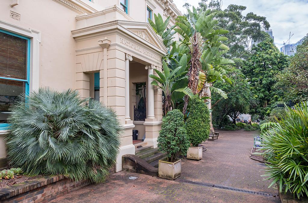 Cream-coloured heritage building with Greek columns at the entrance
